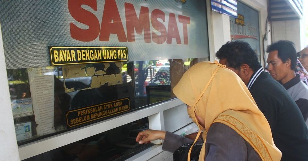 Warga antre di loket pembayaran pajak kendaraan di Samsat Surabaya.