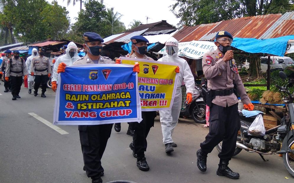 Petugas kepolisian di Padang bersama tim lainnya dengan menggunakan APD tengah melakukan sosialisasi tentang Perda Adaptasi Kebiasaan Baru kepada masyarakat dan pelaku usaha yang ada di Pasar Tanjung Aur Padang/Foto: M Hendra/KabarMinang.id