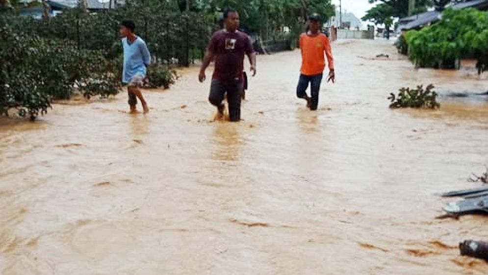 Sejumlah warga saat menerobos banjir yang terjadi di Sungai Pisang/Foto: BPBD