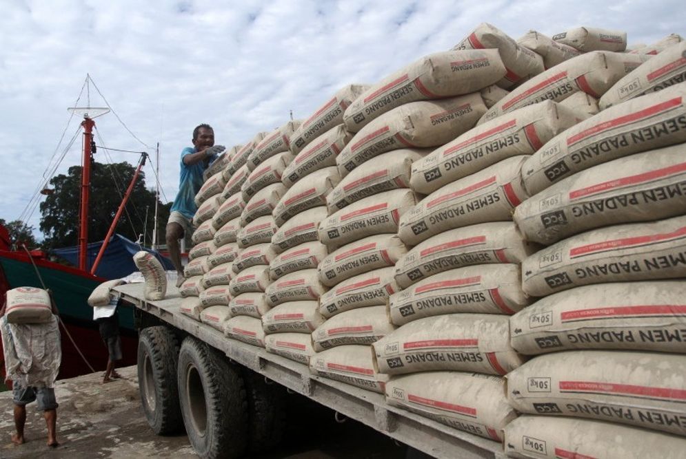 Pekerja mengangkat karung semen dari mobil untuk didistribusikan ke atas kapal di pelabuhan Muaro Padang/Foto: Antara/Muhammad Arif Pribadi