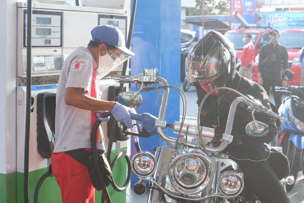 Petugas SPBU melayani konsumen yang membeli BBM.