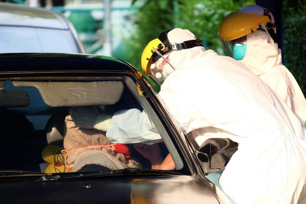 Petugas medis mengambil sampel spesimen saat swab test secara drive thru di halaman Laboratorium Kesehataan Daerah (LABKESDA) Kota Tangerang, Banten/Foto: Ismail Pohan/TrenAsia