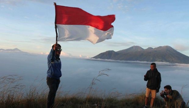 Pendaki berfoto dengan bendera merah putih di atas puncak gunung Penanggungan/TEMPO/Aris Novia Hidayat