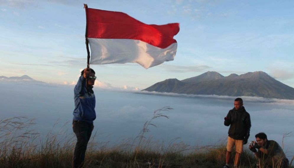 Pendaki berfoto dengan bendera merah putih di atas puncak gunung Penanggungan/TEMPO/Aris Novia Hidayat