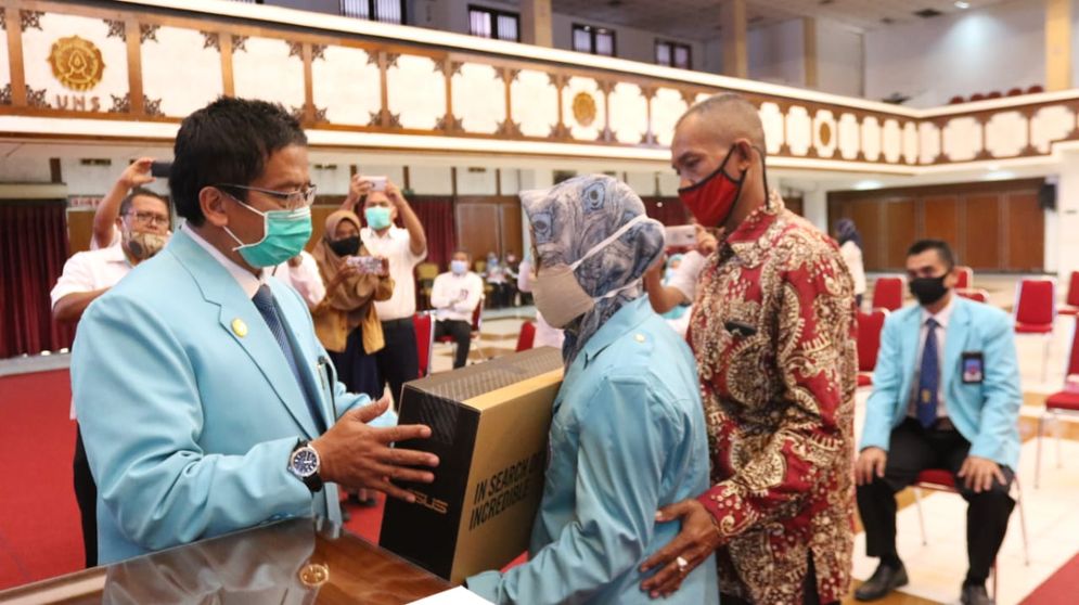 Rektor UNS menyerahkan bantuan laptop pada mana disabilitas