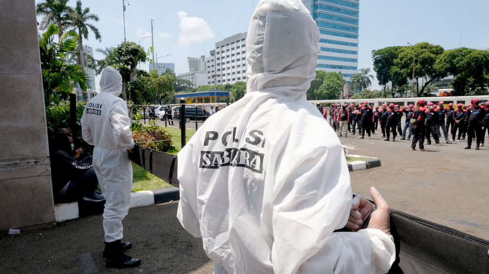 <p>Petugas kepolisian mengenakan hazmat saat mengawal aksi unjuk rasa buruh di depan komplek Parlemen, Senayan, Jakarta, Rabu, 30 September 2020. Aksi unjuk rasa terkait Omnibus Law Cipta Kerja oleh elemen buruh yang menilai panja baleg DPR RI bersama pemerintah belum sesuai harapan buruh. Aksi ini merupakan pemanasan jelang aksi mogok nasional buruh dan demonstrasi besar yang akan diadakan pada tanggal 6-8 Oktober 2020. Foto: Ismail Pohan/TrenAsia</p>
