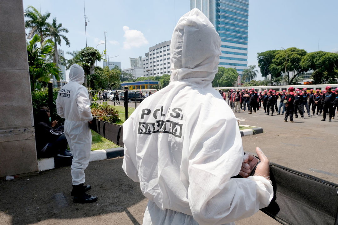 <p>Petugas kepolisian mengenakan hazmat saat mengawal aksi unjuk rasa buruh di depan komplek Parlemen, Senayan, Jakarta, Rabu, 30 September 2020. Aksi unjuk rasa terkait Omnibus Law Cipta Kerja oleh elemen buruh yang menilai panja baleg DPR RI bersama pemerintah belum sesuai harapan buruh. Aksi ini merupakan pemanasan jelang aksi mogok nasional buruh dan demonstrasi besar yang akan diadakan pada tanggal 6-8 Oktober 2020. Foto: Ismail Pohan/TrenAsia</p>
