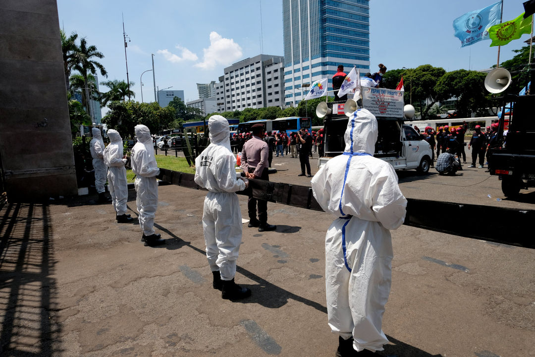 <p>Petugas kepolisian mengenakan hazmat saat mengawal aksi unjuk rasa buruh di depan komplek Parlemen, Senayan, Jakarta, Rabu, 30 September 2020. Aksi unjuk rasa terkait Omnibus Law Cipta Kerja oleh elemen buruh yang menilai panja baleg DPR RI bersama pemerintah belum sesuai harapan buruh. Aksi ini merupakan pemanasan jelang aksi mogok nasional buruh dan demonstrasi besar yang akan diadakan pada tanggal 6-8 Oktober 2020. Foto: Ismail Pohan/TrenAsia</p>
