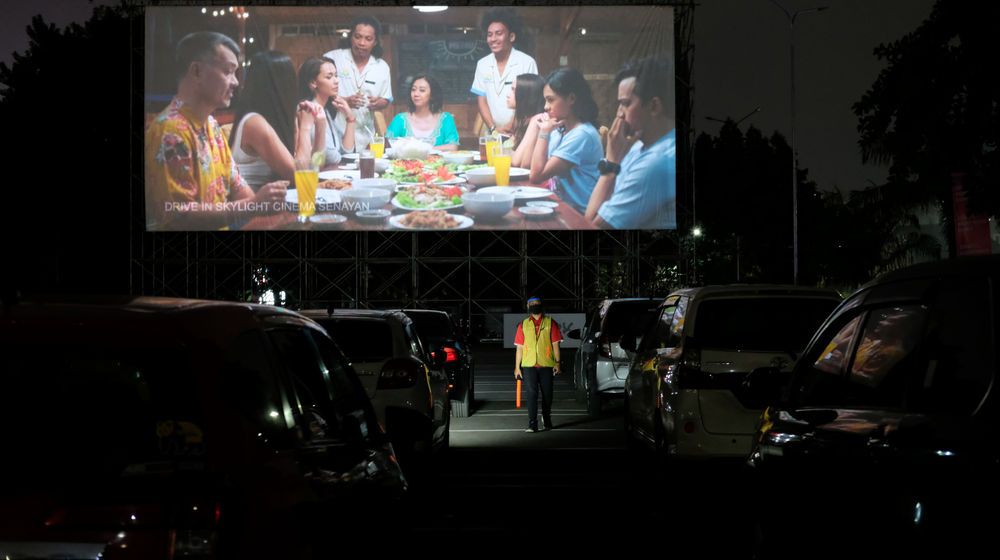 <p>Pengunjung menyaksikan film dari kendaraannya di area cinema drive-in yang diberi nama “Skylight Cinema” di Senayan Park, Jakarta, Minggu, 6 September 2020. Bioskop drive-in yang pertama hadir di Jakarta ini untuk memenuhi keinginan masyarakat menonton bioskop di area terbuka dengan menggunakan mobil pribadi sehingga penonton tidak perlu khawatir terpapar Covid-19 karena membatasi kontak langsung dengan orang lain selama menonton bioskop dengan protokol kesehatan yang diterapkan. Foto: Ismail Pohan/TrenAsia</p>
