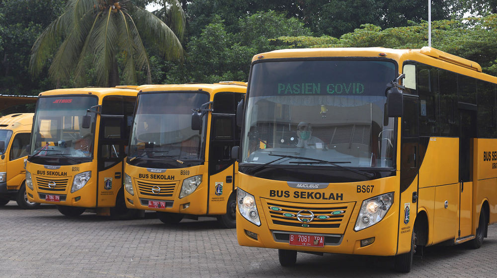 <p>Petugas dengan mengenakan alat pelindung diri (APD) bersiap menjemput pasien tanpa gejala menggunakan bus sekolah yang diperbantukan di Posko Gabungan PSBB dan Gakplin Protkes, Kramat Jati, Jakarta, Selasa, 29 September 2020. Sebanyak 10 bus sekolah yang terdiri dari tujuh bus sedang dan tiga bus kecil dialihfungsikan menjadi kendaraan untuk mengantar pasien COVID-19 berstatus orang tanpa gejala (OTG) menuju lokasi karantina yang disediakan Pemprov DKI Jakarta di Wisma Atlet Kemayoran. Foto: Ismail Pohan/TrenAsia</p>
