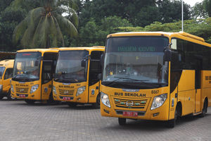 <p>Petugas dengan mengenakan alat pelindung diri (APD) bersiap menjemput pasien tanpa gejala menggunakan bus sekolah yang diperbantukan di Posko Gabungan PSBB dan Gakplin Protkes, Kramat Jati, Jakarta, Selasa, 29 September 2020. Sebanyak 10 bus sekolah yang terdiri dari tujuh bus sedang dan tiga bus kecil dialihfungsikan menjadi kendaraan untuk mengantar pasien COVID-19 berstatus orang tanpa gejala (OTG) menuju lokasi karantina yang disediakan Pemprov DKI Jakarta di Wisma Atlet Kemayoran. Foto: Ismail Pohan/TrenAsia</p>
