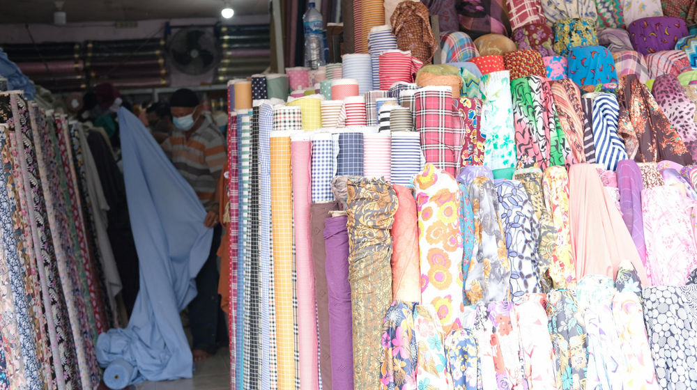 <p>Pedagang menata kain di kiosnya di Pasar Tekstil Cipadu, Tangerang, Banten, Kamis, 17 September 2020. Sekretaris Jenderal Asosiasi Produsen Serat dan Benang Filament Indonesia (APSyFI), Redma Gita Wirawasta mengatakan, penerapan kebijakan Pembatasan Sosial Berskala Besar (PSBB) total DKI Jakarta akan berdampak pada penyerapan produksi tekstil hulu maupun hilir dan berpotensi kehilangan pendapatan US$ 3 miliar per bulan. Foto:Ismail Pohan/TrenAsia</p>
