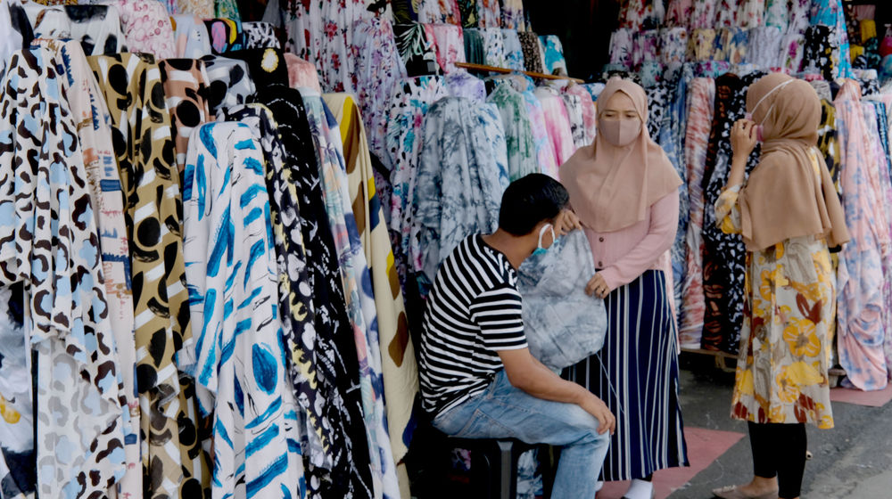 <p>Pembeli memilih produk kain di Pasar Tekstil Cipadu, Tangerang, Banten, Kamis, 17 September 2020. Sekretaris Jenderal Asosiasi Produsen Serat dan Benang Filament Indonesia (APSyFI), Redma Gita Wirawasta mengatakan, penerapan kebijakan Pembatasan Sosial Berskala Besar (PSBB) total DKI Jakarta akan berdampak pada penyerapan produksi tekstil hulu maupun hilir dan berpotensi kehilangan pendapatan US$ 3 miliar per bulan. Foto:Ismail Pohan/TrenAsia</p>
