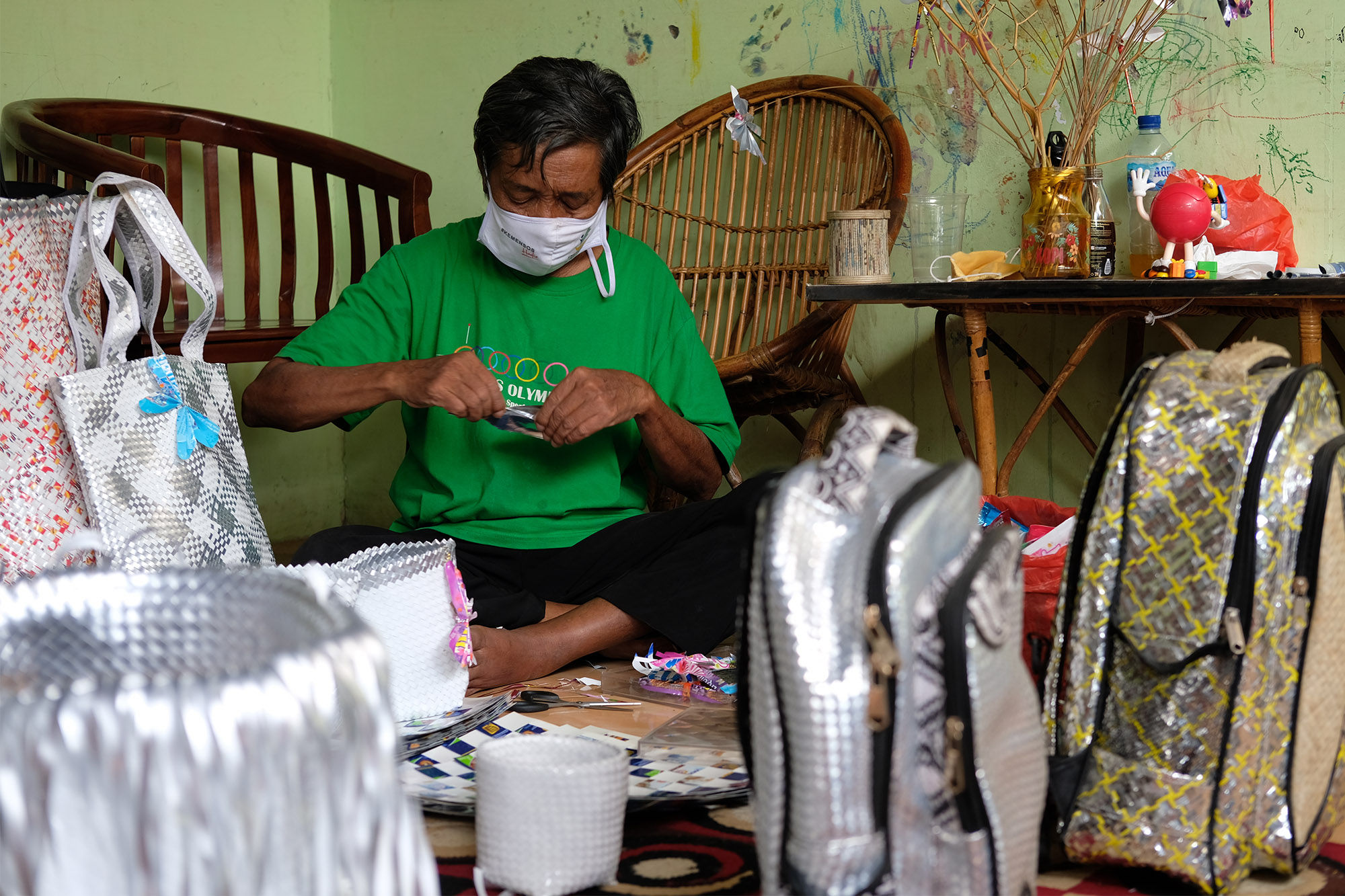 <p>Slamet Riyadi (72) tengah membuat produk kerajinan dari bahan limbah sampah plastik di rumahnya yang dijadikan pondok kreasi lansia bernama Lumintu di Kecamatan Pinang, Tangerang, Banten, Sabtu, 19 September 2020. Nama Lumintu sendiri merupakan singkatan dari &#8220;Lumayan Itung-Itung Nunggu Tutup Usia&#8221; yang didirikan sejak tahun 1998 ini, sudah ada sekitar 40 lansia yang ikut ambil andil dalam memproduksi kerajinan anyaman dari bahan limbah sampah plastik menjadi keranjang, tikar, tas, dompet, dan aksesoris lainnya yang unik. Produk yang awalnya dijual dengan berkeliling kampung ini kini telah merambah ke pasar nasional bahkan internasional dan diharapkan mampu meningkatkan perekonomian di Indonesia. Foto: Ismail Pohan/TrenAsia</p>
