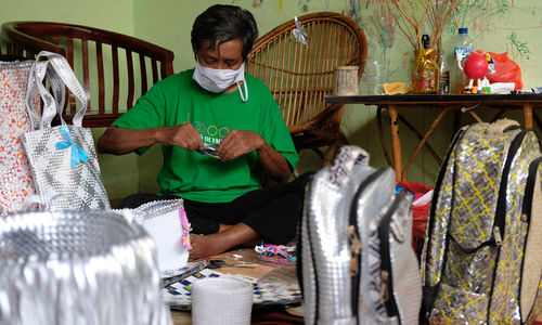 <p>Slamet Riyadi (72) tengah membuat produk kerajinan dari bahan limbah sampah plastik di rumahnya yang dijadikan pondok kreasi lansia bernama Lumintu di Kecamatan Pinang, Tangerang, Banten, Sabtu, 19 September 2020. Nama Lumintu sendiri merupakan singkatan dari &#8220;Lumayan Itung-Itung Nunggu Tutup Usia&#8221; yang didirikan sejak tahun 1998 ini, sudah ada sekitar 40 lansia yang ikut ambil andil dalam memproduksi kerajinan anyaman dari bahan limbah sampah plastik menjadi keranjang, tikar, tas, dompet, dan aksesoris lainnya yang unik. Produk yang awalnya dijual dengan berkeliling kampung ini kini telah merambah ke pasar nasional bahkan internasional dan diharapkan mampu meningkatkan perekonomian di Indonesia. Foto: Ismail Pohan/TrenAsia</p>
