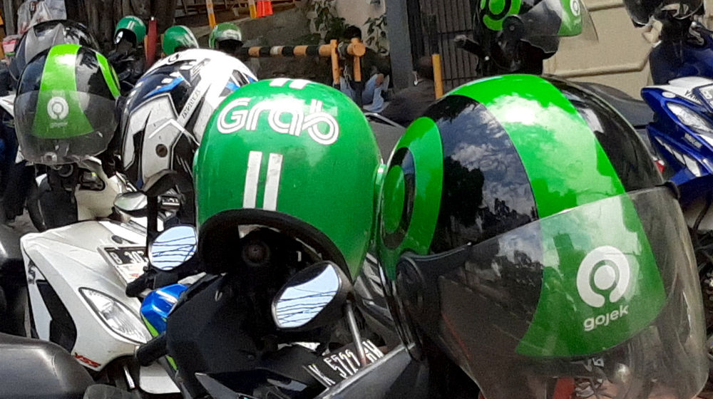 <p>Atribut helm pengemudi ojek daring GrabBike dan Gojek tampak di atas armada yang terparkir di kawasan Gandaria, Jakarta, Selasa, 22 September 2020. Foto: Ismail Pohan/TrenAsia</p>