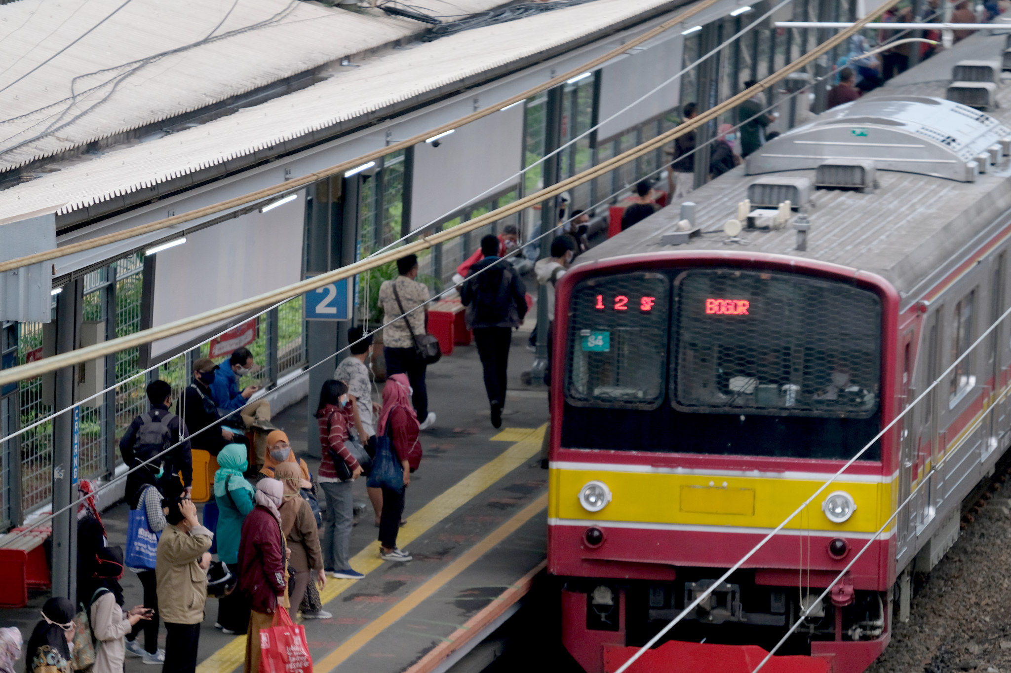 <p>Sejumlah penumpang bersiap menaiki rangkaian kereta listrik (KRL) di Stasiun Cawang, Jakarta, Senin, 14 September 2020. Pengguna transportasi KRL menurun drastis saat hari pertama pemberlakuan PSSB total. Pengguna KRL tercatat ada 92.546 pengguna atau berkurang hingga 19% dibandingkan Senin 7 September 2020 pekan lalu yang mencapai 114.075 pengguna pada waktu yang sama. Foto: Ismail Pohan/TrenAsia</p>
