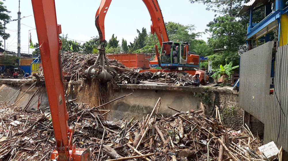 <p>Alat berat mengangkut tumpukan sampah yang menutupi permukaan air di Pintu Air Manggarai, Jakarta Selatan, Selasa, 22 September 2020. Dinas Lingkungan Hidup DKI Jakarta mencatat total 888 ton sampah menumpuk di Pintu Air Manggarai yang terbawa dari aliran Sungai Ciliwung. Jumlah petugas yang dikerahkan adalah 20 orang dengan total armada 20 unit dan tiga jenis alat berat yang digunakan. Foto: Ismail Pohan/TrenAsia</p>