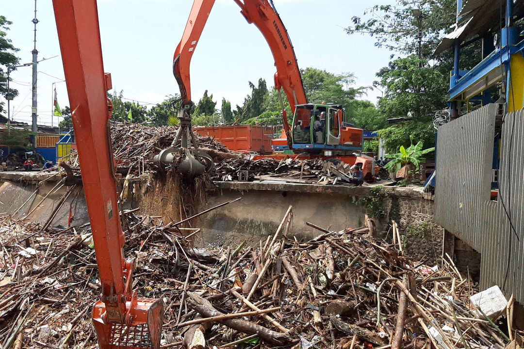 <p>Alat berat mengangkut tumpukan sampah yang menutupi permukaan air di Pintu Air Manggarai, Jakarta Selatan, Selasa, 22 September 2020. Dinas Lingkungan Hidup DKI Jakarta mencatat total 888 ton sampah menumpuk di Pintu Air Manggarai yang terbawa dari aliran Sungai Ciliwung. Jumlah petugas yang dikerahkan adalah 20 orang dengan total armada 20 unit dan tiga jenis alat berat yang digunakan. Foto: Ismail Pohan/TrenAsia</p>
