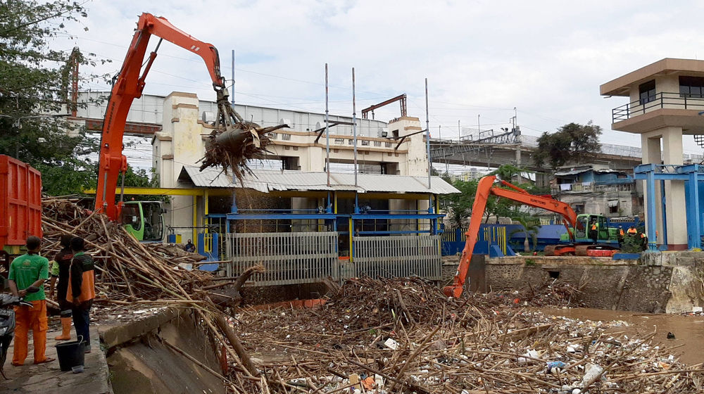 <p>Alat berat mengangkut tumpukan sampah yang menutupi permukaan air di Pintu Air Manggarai, Jakarta Selatan, Selasa, 22 September 2020. Dinas Lingkungan Hidup DKI Jakarta mencatat total 888 ton sampah menumpuk di Pintu Air Manggarai yang terbawa dari aliran Sungai Ciliwung. Jumlah petugas yang dikerahkan adalah 20 orang dengan total armada 20 unit dan tiga jenis alat berat yang digunakan. Foto: Ismail Pohan/TrenAsia</p>