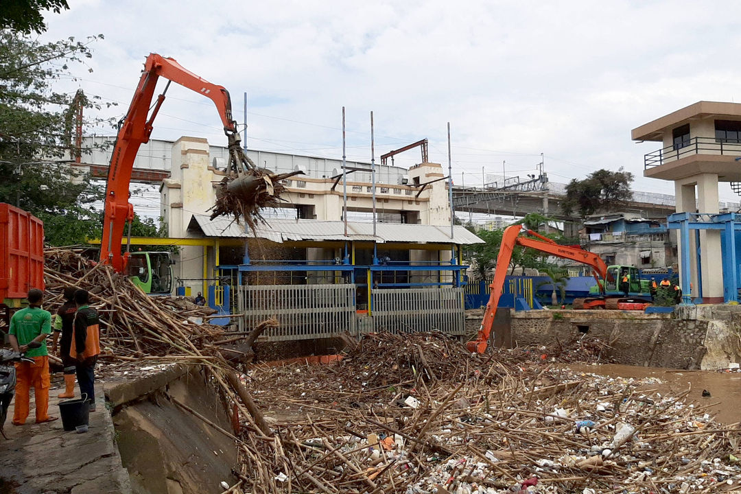 <p>Alat berat mengangkut tumpukan sampah yang menutupi permukaan air di Pintu Air Manggarai, Jakarta Selatan, Selasa, 22 September 2020. Dinas Lingkungan Hidup DKI Jakarta mencatat total 888 ton sampah menumpuk di Pintu Air Manggarai yang terbawa dari aliran Sungai Ciliwung. Jumlah petugas yang dikerahkan adalah 20 orang dengan total armada 20 unit dan tiga jenis alat berat yang digunakan. Foto: Ismail Pohan/TrenAsia</p>
