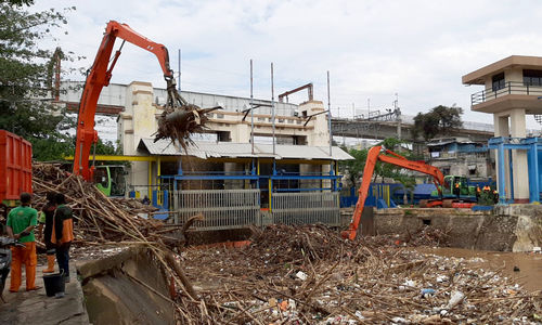 <p>Alat berat mengangkut tumpukan sampah yang menutupi permukaan air di Pintu Air Manggarai, Jakarta Selatan, Selasa, 22 September 2020. Dinas Lingkungan Hidup DKI Jakarta mencatat total 888 ton sampah menumpuk di Pintu Air Manggarai yang terbawa dari aliran Sungai Ciliwung. Jumlah petugas yang dikerahkan adalah 20 orang dengan total armada 20 unit dan tiga jenis alat berat yang digunakan. Foto: Ismail Pohan/TrenAsia</p>
