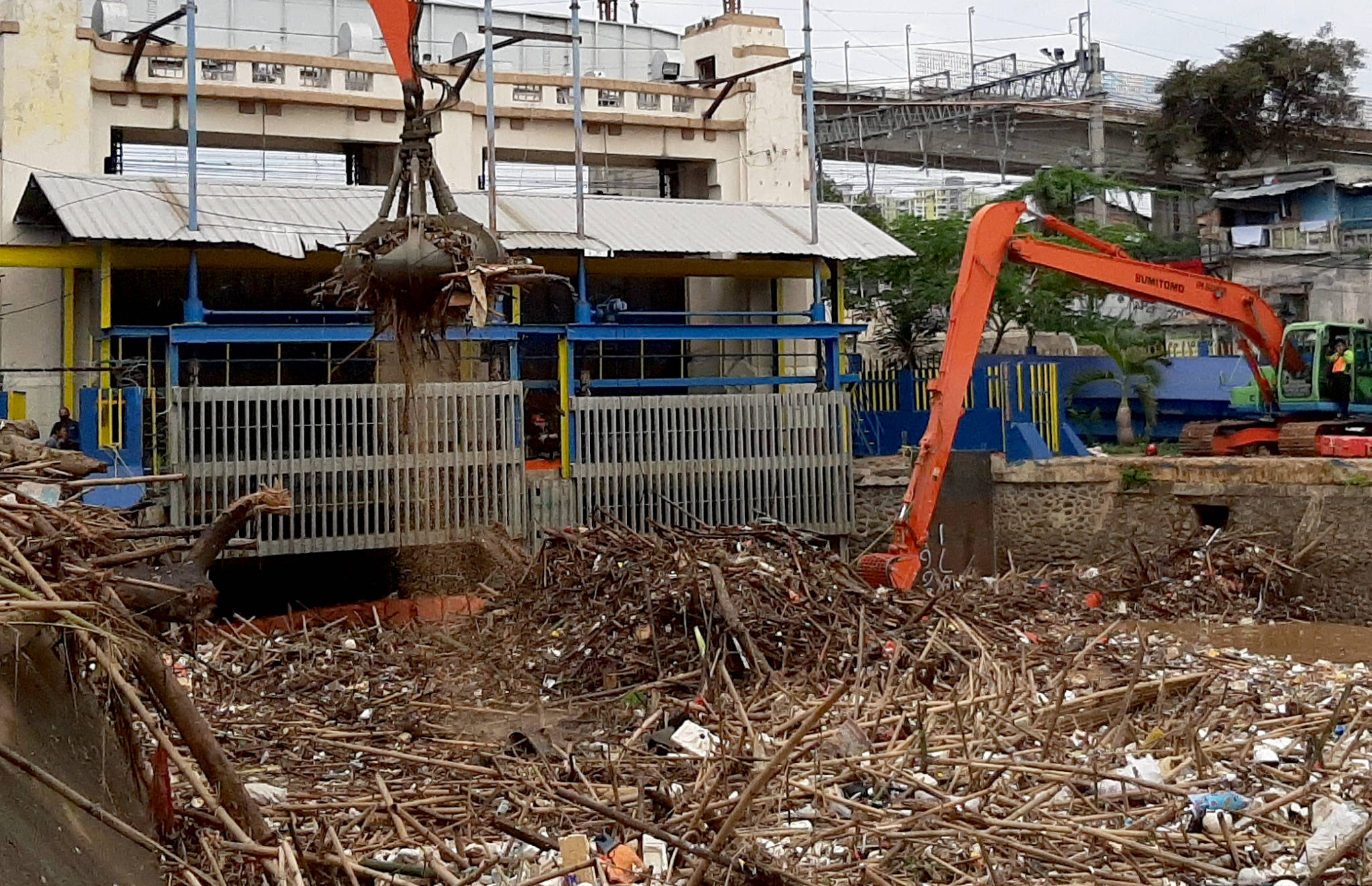 <p>Alat berat mengangkut tumpukan sampah yang menutupi permukaan air di Pintu Air Manggarai, Jakarta Selatan, Selasa, 22 September 2020. Dinas Lingkungan Hidup DKI Jakarta mencatat total 888 ton sampah menumpuk di Pintu Air Manggarai yang terbawa dari aliran Sungai Ciliwung. Jumlah petugas yang dikerahkan adalah 20 orang dengan total armada 20 unit dan tiga jenis alat berat yang digunakan. Foto: Ismail Pohan/TrenAsia</p>
