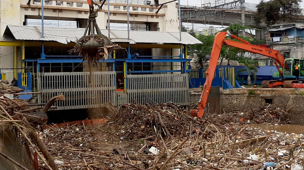 <p>Alat berat mengangkut tumpukan sampah yang menutupi permukaan air di Pintu Air Manggarai, Jakarta Selatan, Selasa, 22 September 2020. Dinas Lingkungan Hidup DKI Jakarta mencatat total 888 ton sampah menumpuk di Pintu Air Manggarai yang terbawa dari aliran Sungai Ciliwung. Jumlah petugas yang dikerahkan adalah 20 orang dengan total armada 20 unit dan tiga jenis alat berat yang digunakan. Foto: Ismail Pohan/TrenAsia</p>
