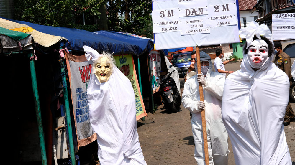 <p>Pegawai Kecamatan dengan kostum pocong-pocongan dan hazmat melakukan sosialisasi protokol kesehatan Covid-19 di kawasan Pasar Kreo, Kecamatan Larangan, Tangerang, Rabu, 16 September 2020. Sosialisasi ini untuk menekankan kembali kepada warga agar lebih patuh terhadap protokol kesehatan dan selalu menerapkan gerakan 3M, Memakai Masker, Mencuci Tangan, dan Menjaga Jarak untuk memutus rantai penyebaran Covid-19. Foto: Ismail Pohan/TrenAsia</p>
