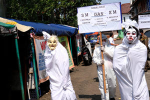 <p>Pegawai Kecamatan dengan kostum pocong-pocongan dan hazmat melakukan sosialisasi protokol kesehatan Covid-19 di kawasan Pasar Kreo, Kecamatan Larangan, Tangerang, Rabu, 16 September 2020. Sosialisasi ini untuk menekankan kembali kepada warga agar lebih patuh terhadap protokol kesehatan dan selalu menerapkan gerakan 3M, Memakai Masker, Mencuci Tangan, dan Menjaga Jarak untuk memutus rantai penyebaran Covid-19. Foto: Ismail Pohan/TrenAsia</p>
