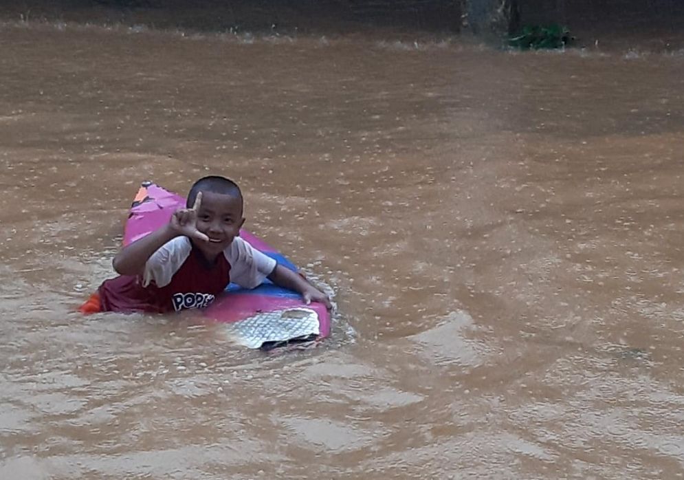 Seorang tengah bermain air di kawasan banjir di Komplek Jondul Rawang Padang yang terjadi hari ini Kamis 1 Oktober 2020/Foto: Bobi