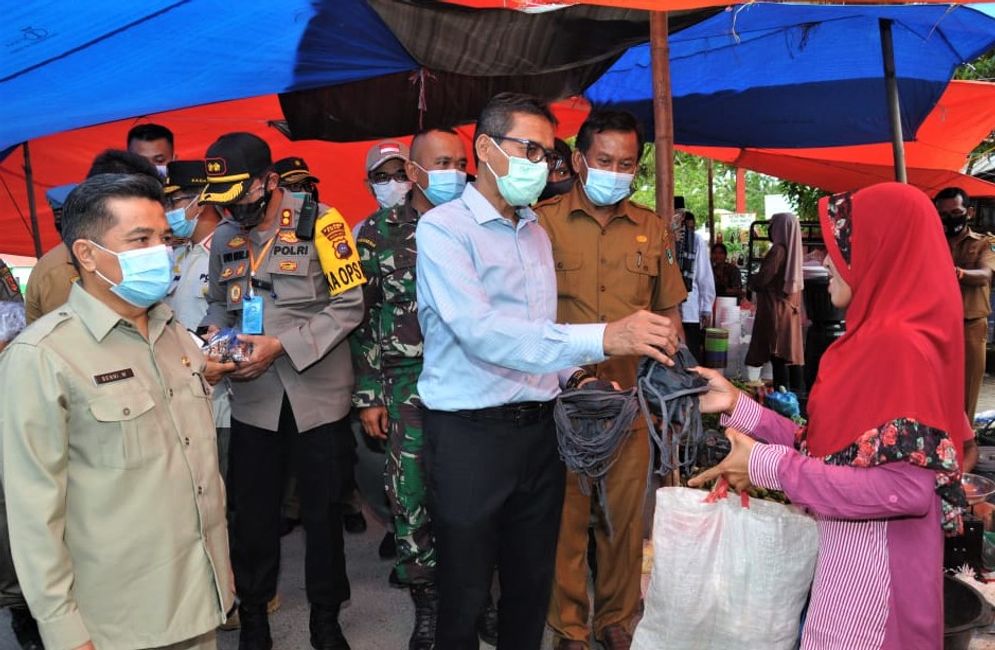 Gubernur Sumbar Irwan Prayitno saat membagikan masker sebagai bentuk sosialisasi Perda AKB bagi warga Tanjung Mutiara Kabupaten Agam/Foto: ist