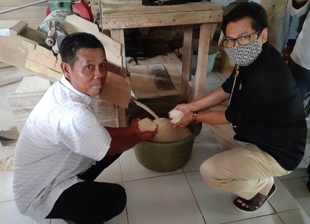 Plt Kepala Dinas Pangan Tanaman Pangan dan Hortikultura (TPH) Kaltim Dadang Sudarya bersama petani memperlihatkan beras