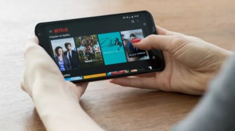 Ilustrasi menonton aplikasi Neflix melalui Smartphone.