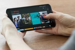 Ilustrasi menonton aplikasi Neflix melalui Smartphone.