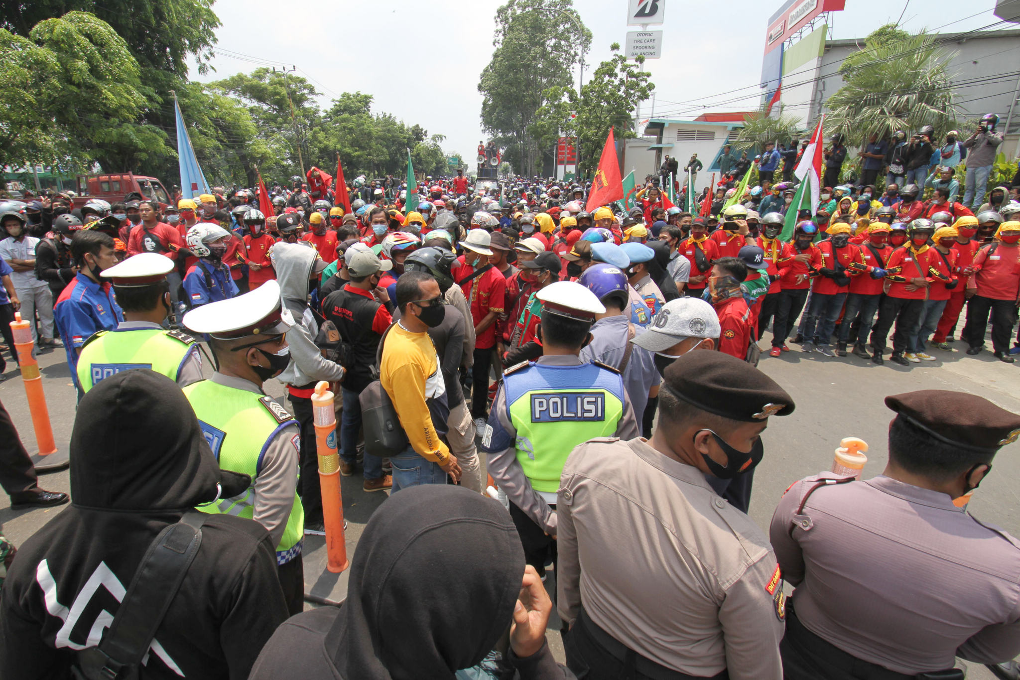 <p>Aparat kepolisian tampak mengawal buruh yang mengikuti aksi unjuk rasa di Jalan Daan Mogot, Kota Tangerang, Banten, Rabu, 7 Oktober 2020. Aksi tersebut sebagai bentuk kekecewaan buruh atas pengesahan Undang-Undang Cipta Kerja oleh DPR yang dianggap merugikan kaum buruh. Foto: Panji Asmoro/TrenAsia</p>
