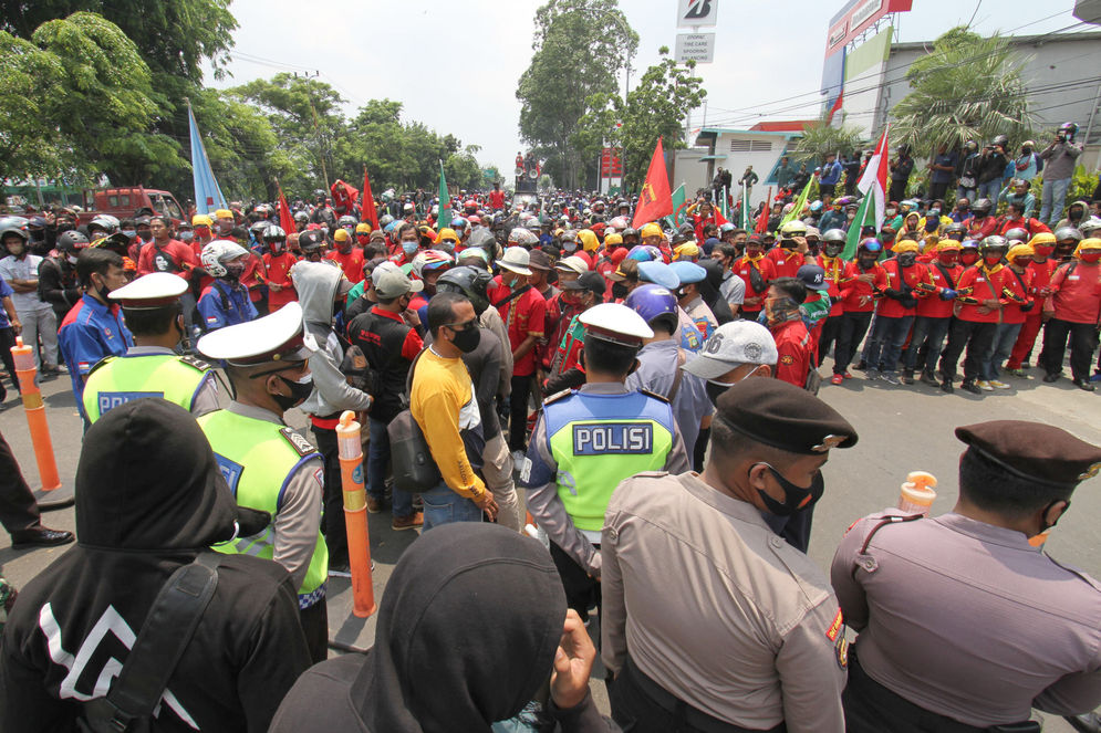 Aparat kepolisian tampak mengawal buruh yang mengikuti aksi unjuk rasa di Jalan Daan Mogot, Kota Tangerang, Banten, Rabu, 7 Oktober 2020. Aksi tersebut sebagai bentuk kekecewaan buruh atas pengesahan Undang-Undang Cipta Kerja oleh DPR yang dianggap merugikan kaum buruh