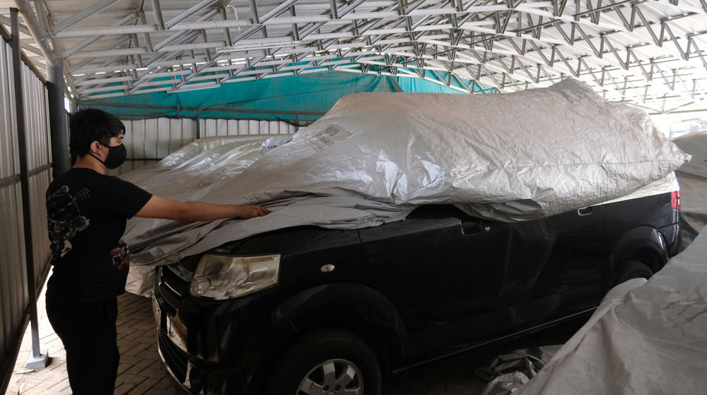 <p>Pekerja membungkus mobil yang digadaikan di gudang penyimpanan kendaraan PT Pegadaian (Persero), Kebon Nanas, Jakarta Timur, Kamis, 15 Oktober 2020. Pandemi Covid-19 menyebabkan nasabah ingin mendapatkan dana cepat dengan menggadaikan mobilnya. Jumlah nasabah yang ingin menggadaikan kendaraannya di pegadaian pun terus meningkat. Saat ini gudang penyimpanan mobil gadai dengan kapasitas 220, telah terisi sebanyak 209 unit mobil yang digadaikan. Foto: Ismail Pohan/TrenAsia</p>

