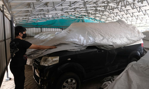 <p>Pekerja membungkus mobil yang digadaikan di gudang penyimpanan kendaraan PT Pegadaian (Persero), Kebon Nanas, Jakarta Timur, Kamis, 15 Oktober 2020. Pandemi Covid-19 menyebabkan nasabah ingin mendapatkan dana cepat dengan menggadaikan mobilnya. Jumlah nasabah yang ingin menggadaikan kendaraannya di pegadaian pun terus meningkat. Saat ini gudang penyimpanan mobil gadai dengan kapasitas 220, telah terisi sebanyak 209 unit mobil yang digadaikan. Foto: Ismail Pohan/TrenAsia</p>
