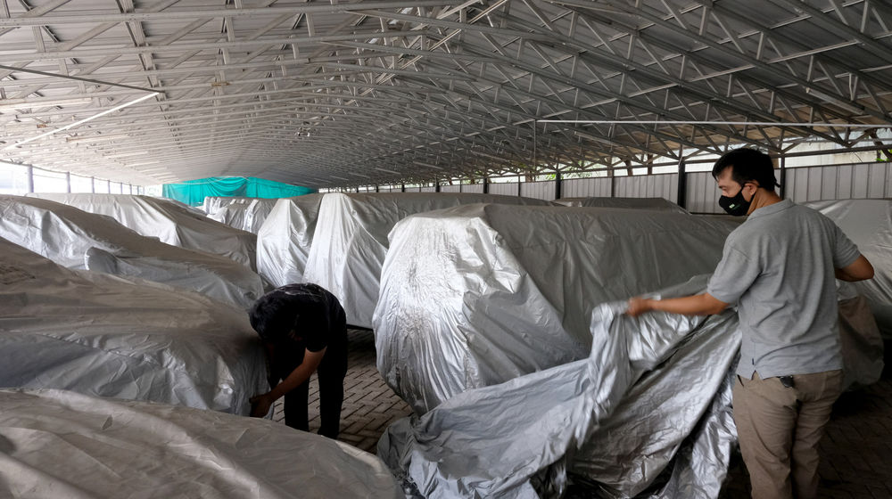 <p>Pekerja membungkus mobil yang digadaikan di gudang penyimpanan kendaraan PT Pegadaian (Persero), Kebon Nanas, Jakarta Timur, Kamis, 15 Oktober 2020. Pandemi Covid-19 menyebabkan nasabah ingin mendapatkan dana cepat dengan menggadaikan mobilnya. Jumlah nasabah yang ingin menggadaikan kendaraannya di pegadaian pun terus meningkat. Saat ini gudang penyimpanan mobil gadai dengan kapasitas 220, telah terisi sebanyak 209 unit mobil yang digadaikan. Foto: Ismail Pohan/TrenAsia</p>
