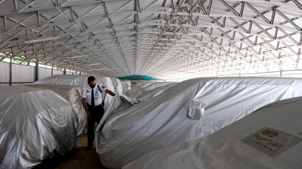 <p>Petugas keamanan memeriksa unit mobil yang digadaikan di gudang penyimpanan kendaraan PT Pegadaian (Persero), Kebon Nanas, Jakarta Timur, Kamis, 15 Oktober 2020. Pandemi Covid-19 menyebabkan nasabah ingin mendapatkan dana cepat dengan menggadaikan mobilnya. Jumlah nasabah yang ingin menggadaikan kendaraannya di pegadaian pun terus meningkat. Saat ini gudang penyimpanan mobil gadai dengan kapasitas 220, telah terisi sebanyak 209 unit mobil yang digadaikan. Foto: Ismail Pohan/TrenAsia</p>
