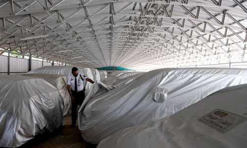 <p>Petugas keamanan memeriksa unit mobil yang digadaikan di gudang penyimpanan kendaraan PT Pegadaian (Persero), Kebon Nanas, Jakarta Timur, Kamis, 15 Oktober 2020. Pandemi Covid-19 menyebabkan nasabah ingin mendapatkan dana cepat dengan menggadaikan mobilnya. Jumlah nasabah yang ingin menggadaikan kendaraannya di pegadaian pun terus meningkat. Saat ini gudang penyimpanan mobil gadai dengan kapasitas 220, telah terisi sebanyak 209 unit mobil yang digadaikan. Foto: Ismail Pohan/TrenAsia</p>
