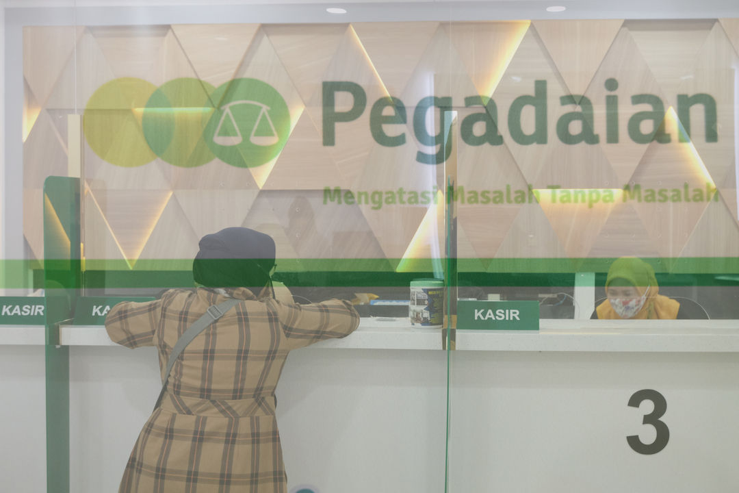 <p>Nasabah melakukan transaksi di kantor pelayanan PT Pegadaian (Persero) Pusat, Jakarta, Kamis, 15 Oktober 2020. Pandemi Covid-19 menyebabkan nasabah ingin mendapatkan dana cepat dengan menggadaikan mobilnya. Jumlah nasabah yang ingin menggadaikan kendaraannya di pegadaian pun terus meningkat. Saat ini gudang penyimpanan mobil gadai dengan kapasitas 220, telah terisi sebanyak 209 unit mobil yang digadaikan. Foto: Ismail Pohan/TrenAsia</p>
