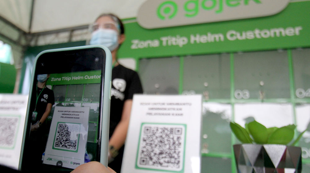 <p>Warga melakukan scan barcode untuk menggunakan fasilitas titip helm saat peresmian Zona Nyaman J3K Gojek di Stasiun Depok Baru pada Senin, 26 Oktober 2020. Foto: Panji Asmoro/TrenAsia</p>
