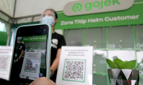 <p>Warga melakukan scan barcode untuk menggunakan fasilitas titip helm saat peresmian Zona Nyaman J3K Gojek di Stasiun Depok Baru pada Senin, 26 Oktober 2020. Foto: Panji Asmoro/TrenAsia</p>