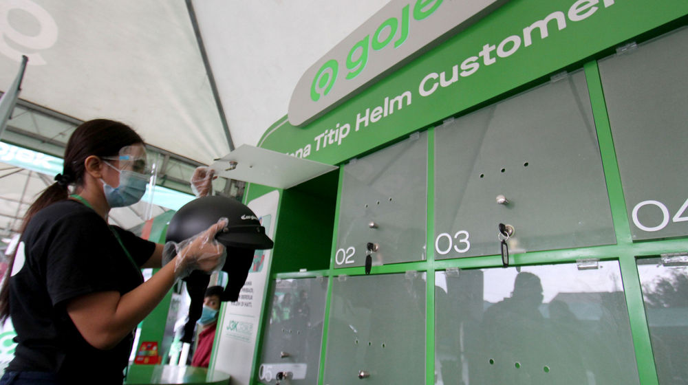 <p>Petugas bersiap menyimpan helm customer gojek yang dititipkan saat peresmian Zona Nyaman J3K Gojek di Stasiun Depok Baru pada Senin, 26 Oktober 2020. Foto: Panji Asmoro/TrenAsia</p>
