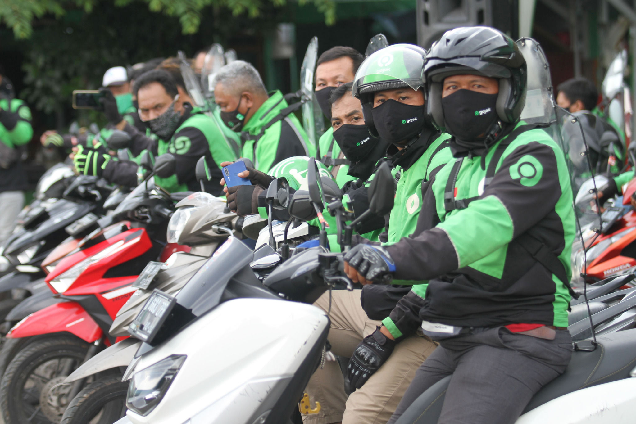 <p>Mitra driver Gojek menunggu penumpang di area Zona Nyaman J3K Gojek Stasiun Depok Baru pada Senin, 26 Oktober 2020. Foto: Panji Asmoro/TrenAsia</p>
