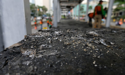 <p>Petugas membersihan puing-puing Halte Transjakarta yang rusak dan dibakar massa saat aksi unjuk rasa menolak pengesahan UU Cipta Kerja yang berakhir ricuh di kawasan Thamrin, Jum’at, 9 Oktober 2020. Sejumlah fasilitas umum rusak dan dibakar massa yang mengamuk imbas dari demonstrasi omnibus law yang berujung kericuhan. Pemprov DKI Jakarta menyebut kerugian akibat kerusakan mencapai puluhan miliar Rupiah. Foto: Ismail Pohan/TrenAsia</p>
