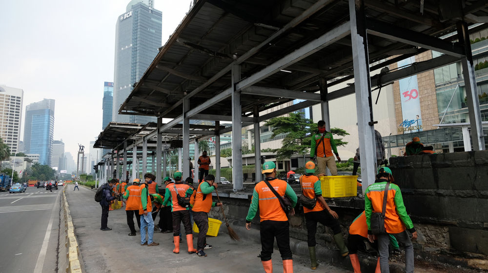 <p>Petugas membersihkan sisa puing di halte Transjakarta yang rusak dan dibakar massa saat aksi unjuk rasa menolak pengesahan UU Cipta Kerja yang berakhir ricuh di kawasan Thamrin, Jumat, 9 Oktober 2020/ Foto: Ismail Pohan/TrenAsia</p>
