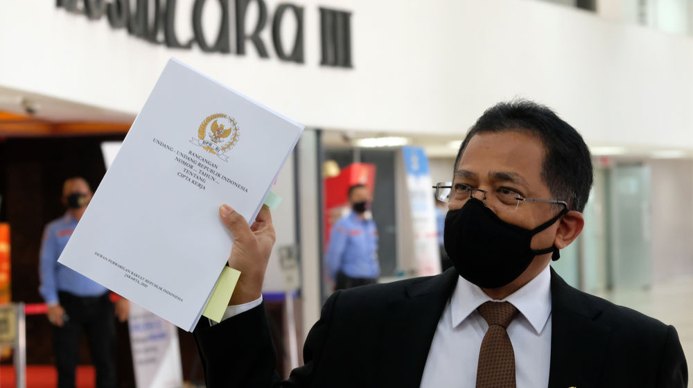 <p>Sekretaris Jenderal DPR RI, Indra Iskandar menunjukkan berkas naskah final Undang-Undang Cipta Kerja yang akan diantarkan kepada Presiden Jokowi dari Gedung DPR, Komplek Parlemen, Senayan, Jakarta, Rabu, 14 Oktober 2020. Dewan Perwakilan Rakyat (DPR) melalui sekretaris jenderal secara resmi menyerahkan draf final Omnibus Law UU Cipta Kerja kepada Presiden Joko Widodo selaku kepala pemerintahan. Nantinya, berkas Omnibus Law UU Cipta Kerja ditandatangani Jokowi sebelum diundangkan oleh Menkumham Yasonna Laoly. DPR memastikan bahwa naskah final UU Cipta Kerja yang akan diserahkan ke Presiden Jokowi esok total berjumlah 812 halaman. Foto: Ismail Pohan/TrenAsia</p>